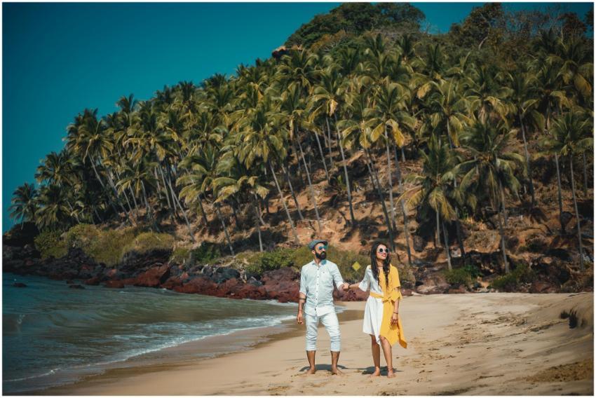 Couple enjoying a sunny beach walk in Goa with lus