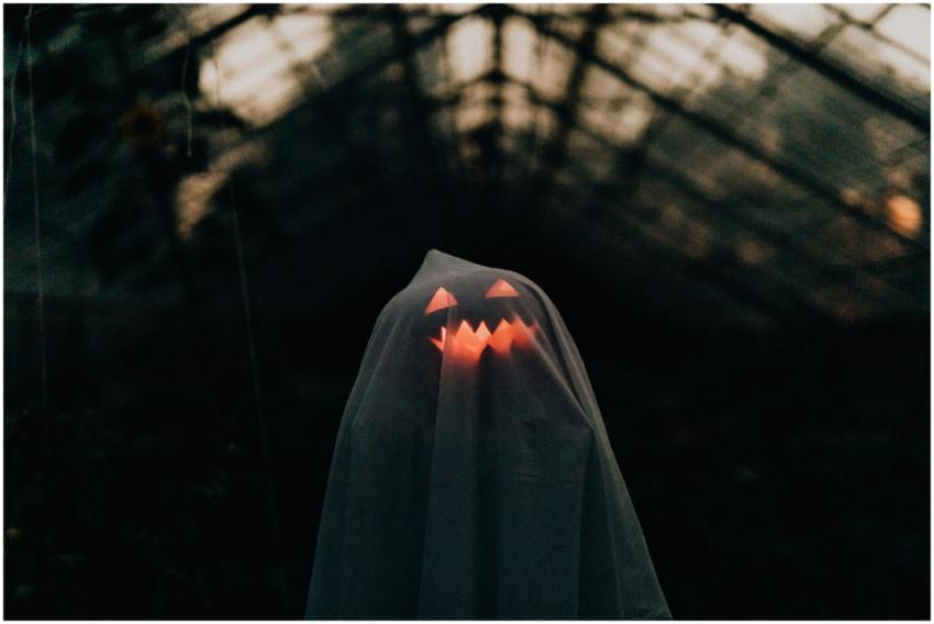 A ghostly figure with a glowing pumpkin face under