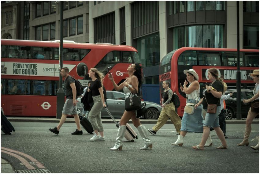 Crowd crossing a London street with iconic red bus