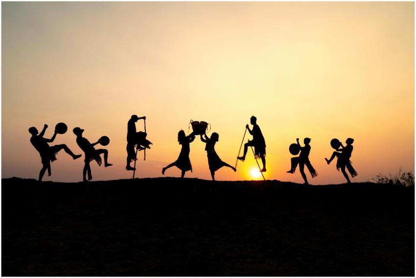 Silhouetted group performing traditional dance at