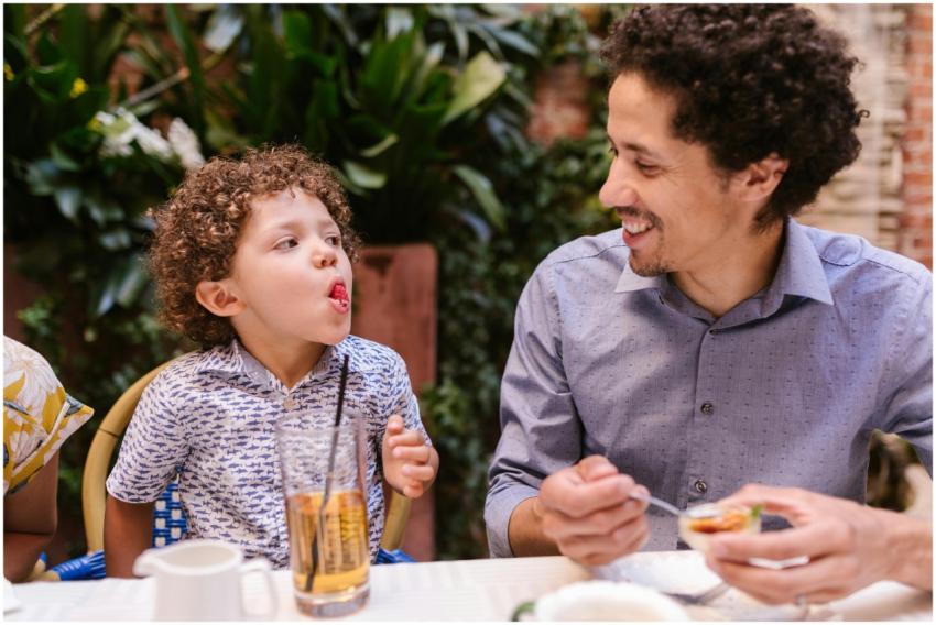 Father and son share a joyful moment while dining