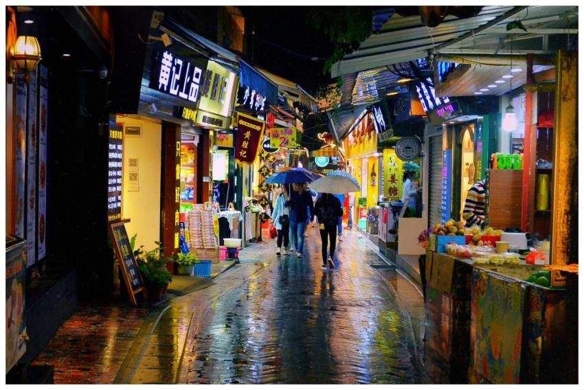 Busy night market street with colorful shops and p