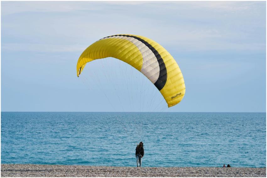 A person paragliding on a picturesque beach, captu