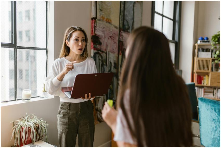 Frustrated mother working on a laptop while talkin