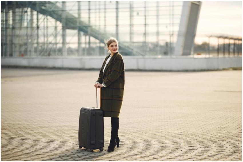Fashionable woman with suitcase at a modern airpor