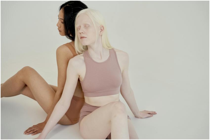 Two diverse women posing back to back in a minimal