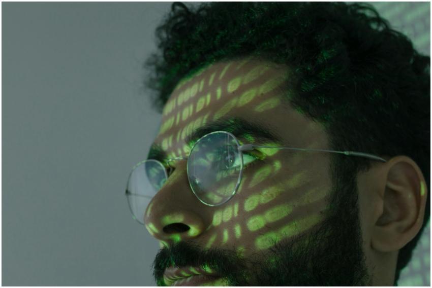 A man wearing glasses with binary code projected a