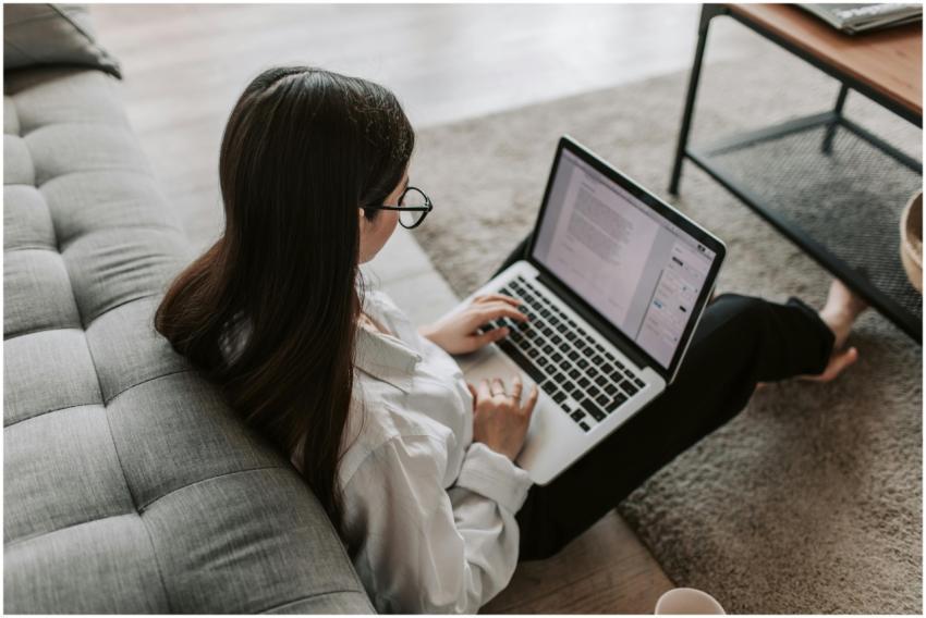 Woman working remotely with a laptop on the floor