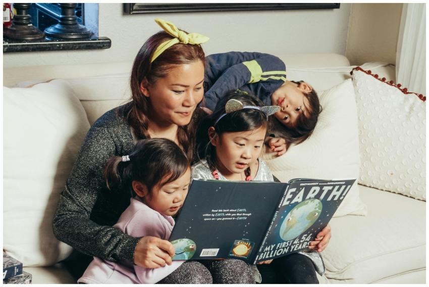 A mother and her children enjoy a book together on