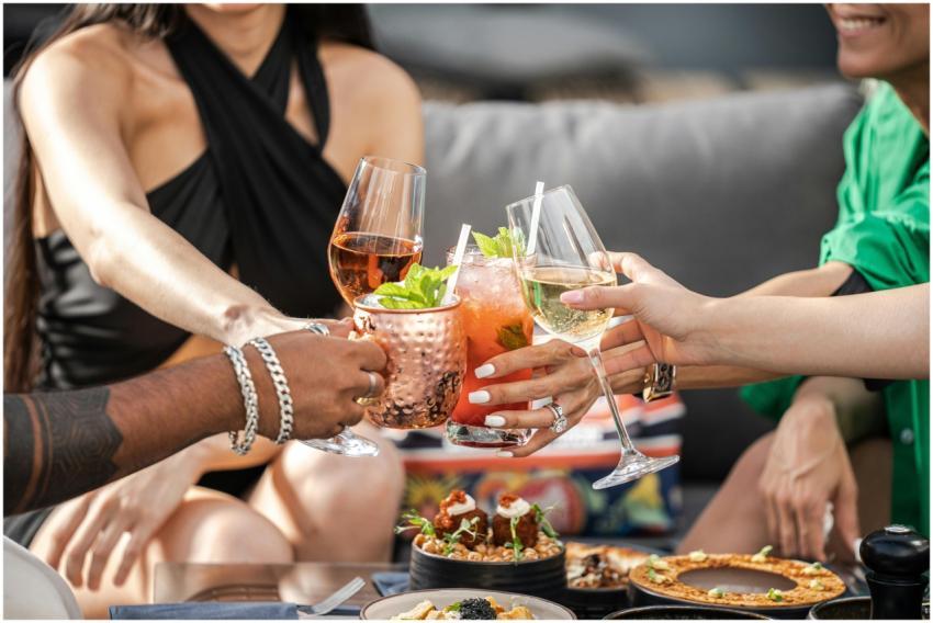 Group of friends clinking glasses with cocktails a