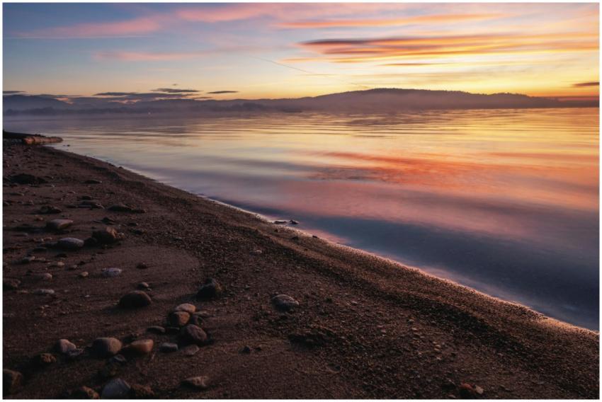A tranquil sunrise scene over a calm lake with viv