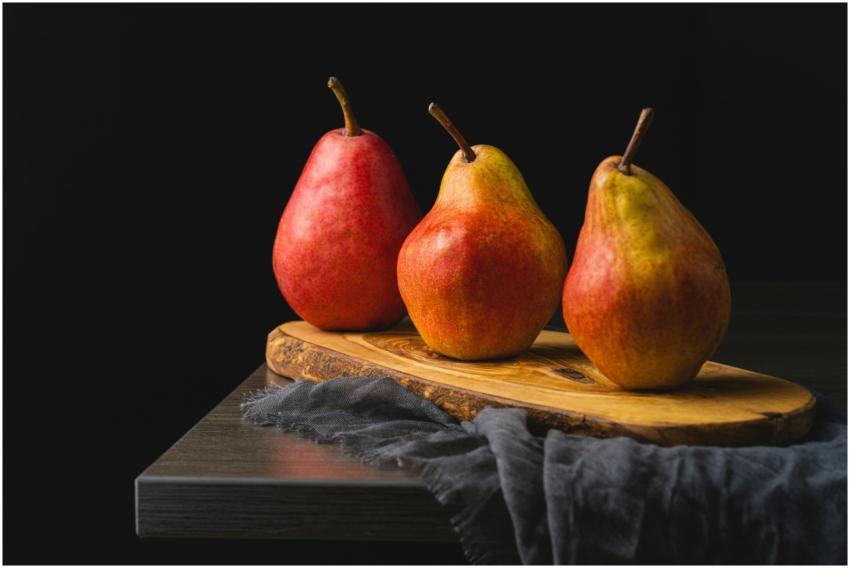 Beautiful display of three ripe red pears on a woo