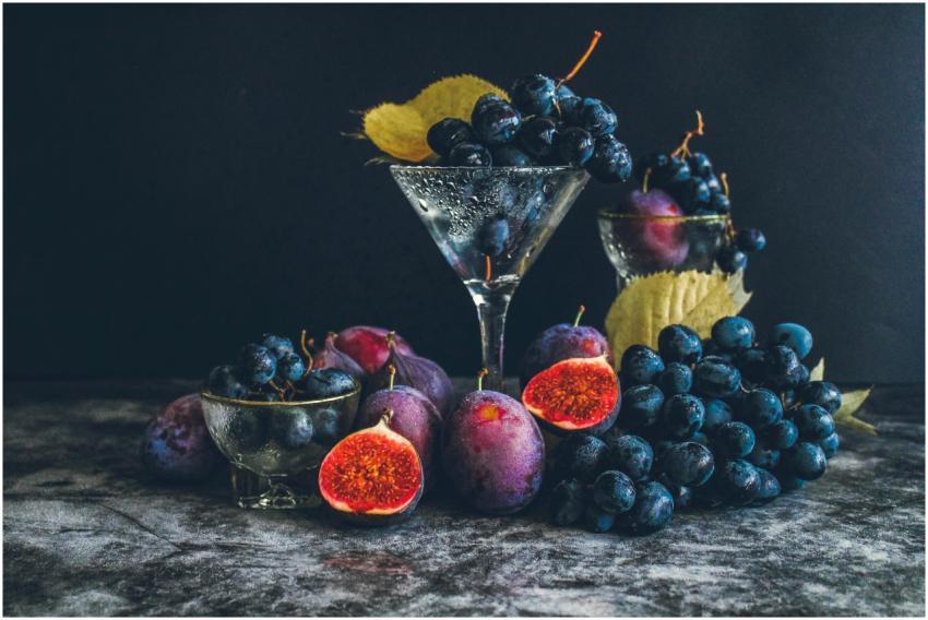 Dark moody still life of fresh grapes and figs in