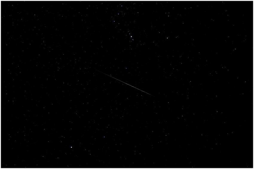 A serene view of a shooting star across a starry s