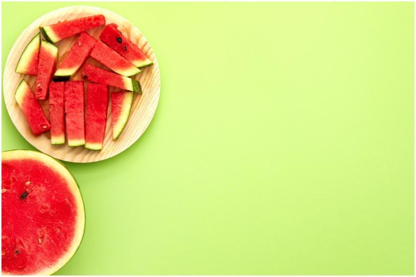 Fresh watermelon slices on a wooden plate against