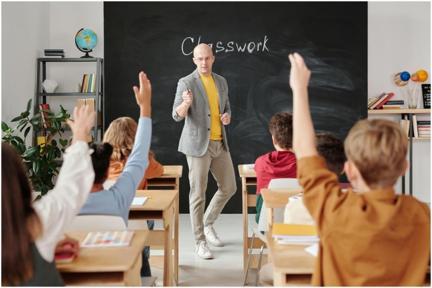 Teacher interacting with students raising hands in