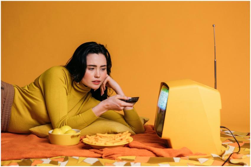 Woman relaxing and watching a vintage television s