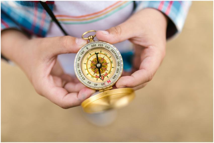 A detailed view of hands holding a vintage compass