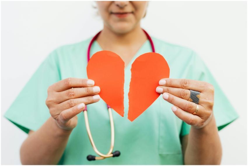 Nurse holding a torn paper heart symbolizing emoti