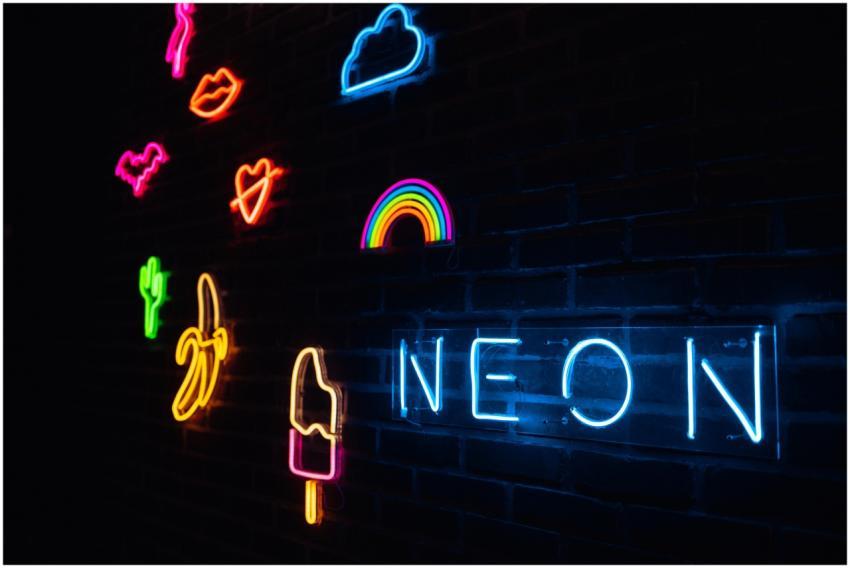 Vibrant neon signs illuminated on a dark brick wal