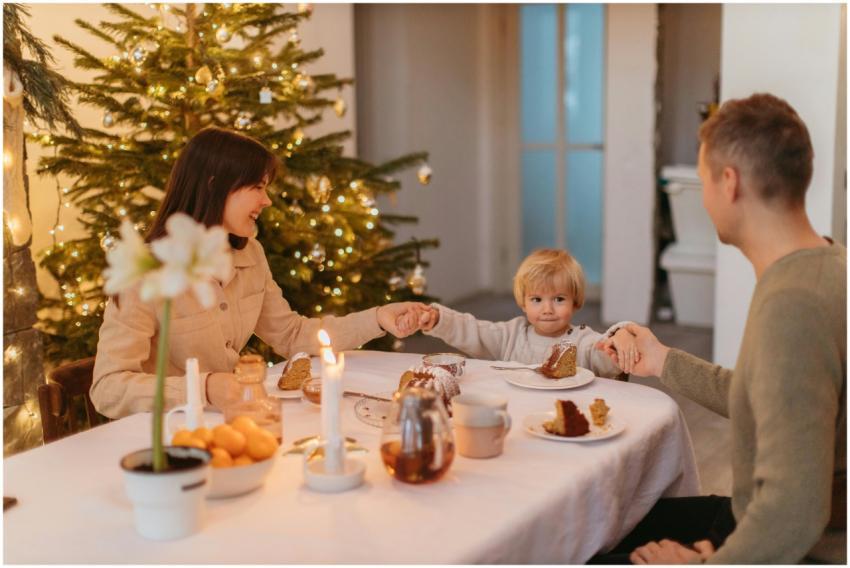 Family enjoying a festive meal by a Christmas tree