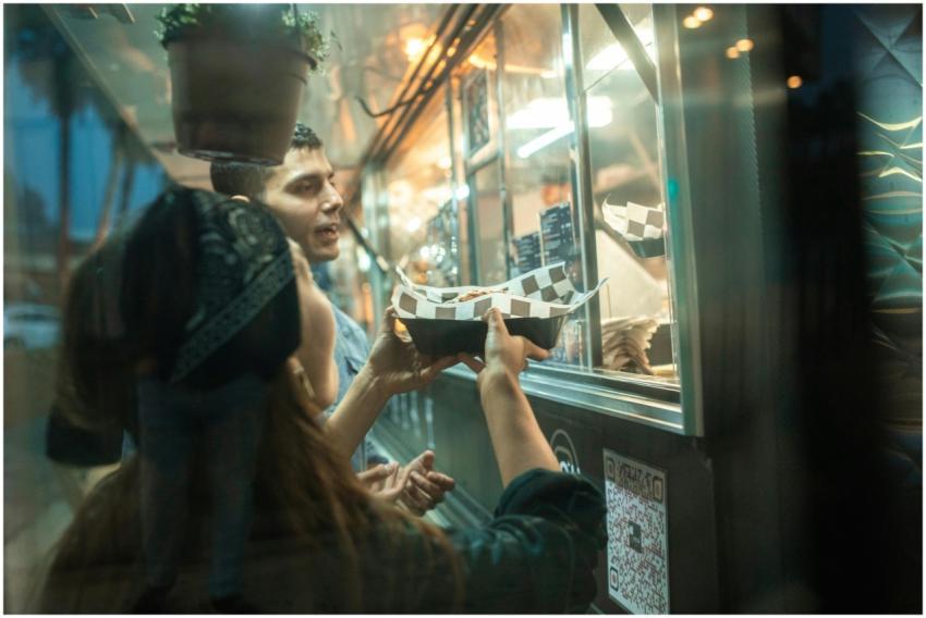 A couple enjoys ordering food from a vibrant stree