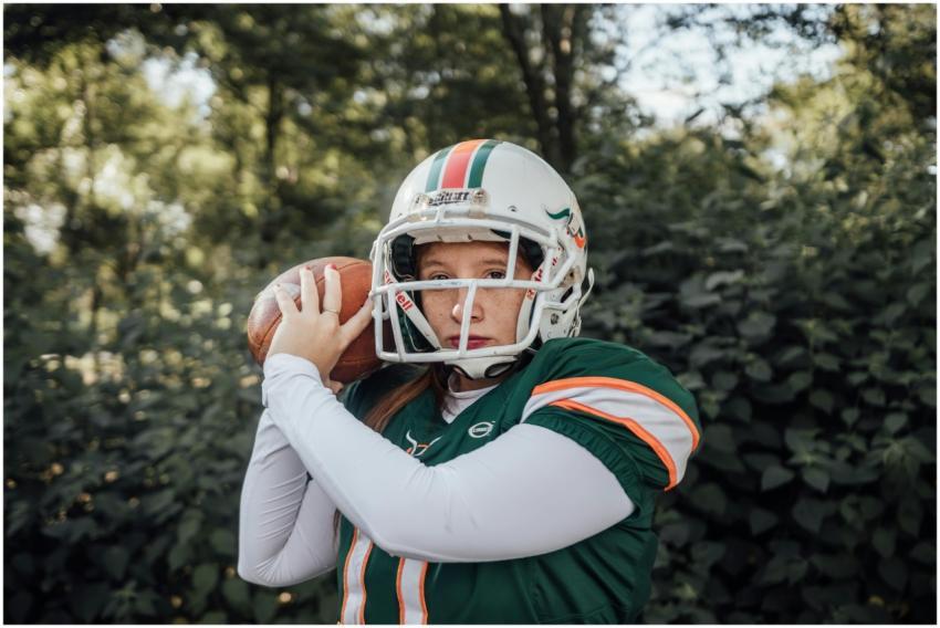 A female athlete in football gear practicing outdo
