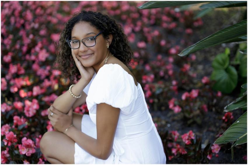 Young woman in white dress with a backdrop of pink