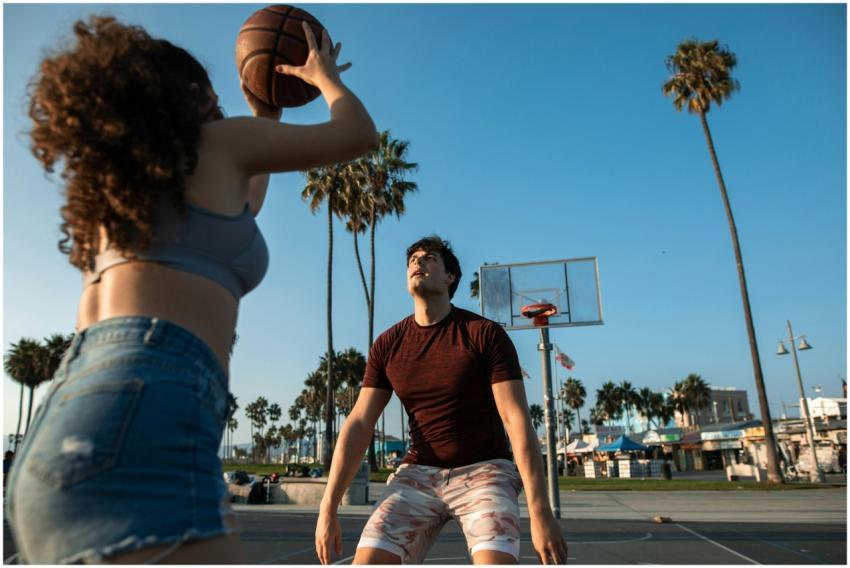 Young adults playing basketball on an outdoor cour