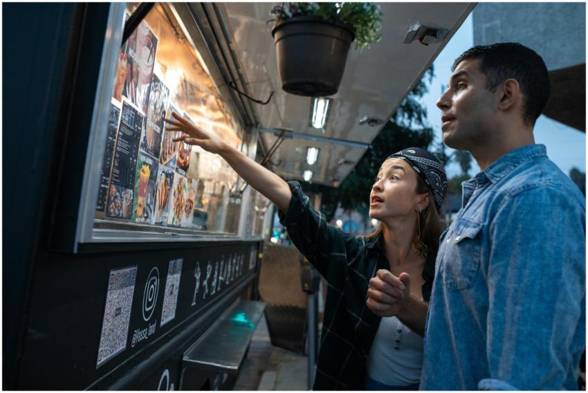 A couple choosing food from a vibrant street food