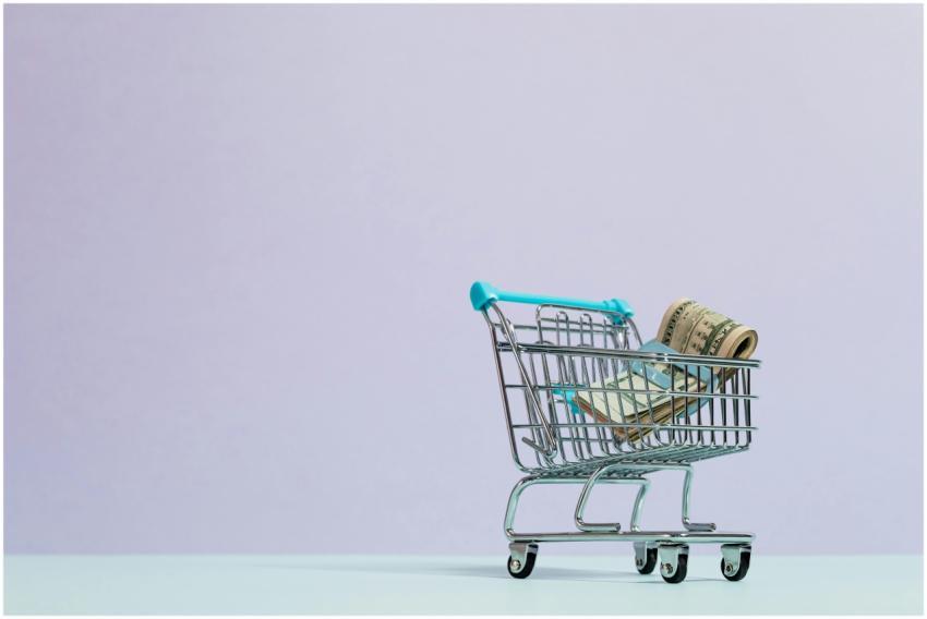A close-up of a mini shopping cart with rolled cas