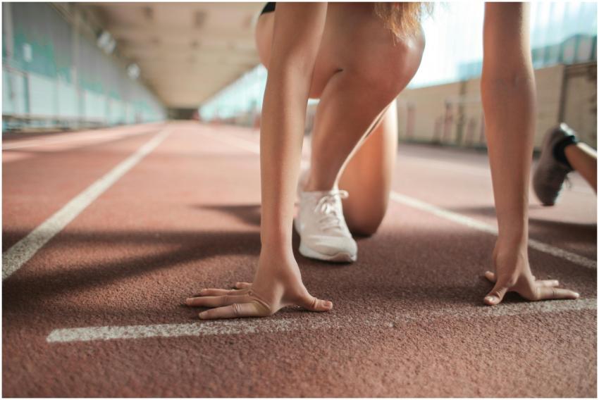 Focused female athlete in crouch start position pr