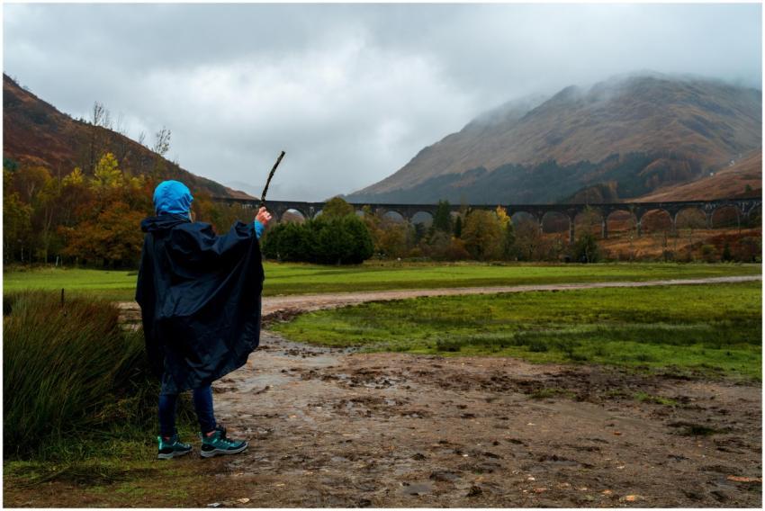 Person in raincoat exploring near the iconic Glenf