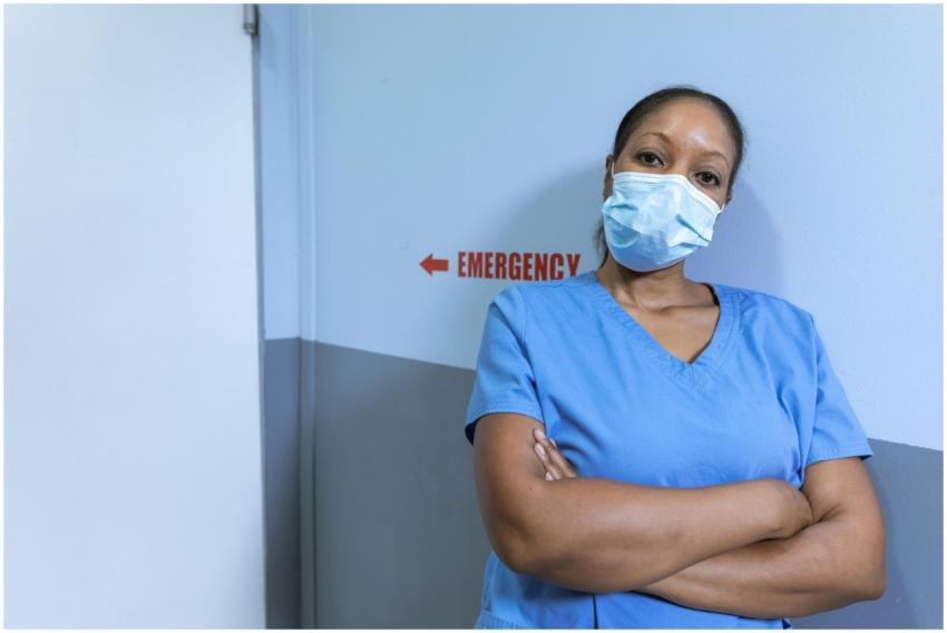 Nurse in blue scrubs and face mask in hospital cor