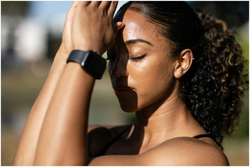 A woman meditates outdoors with eyes closed, embod