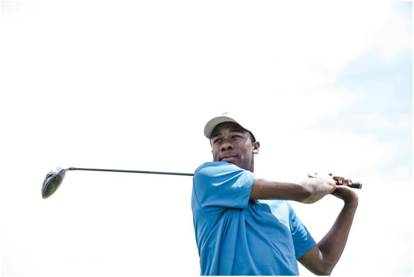 African American man playing golf against a bright