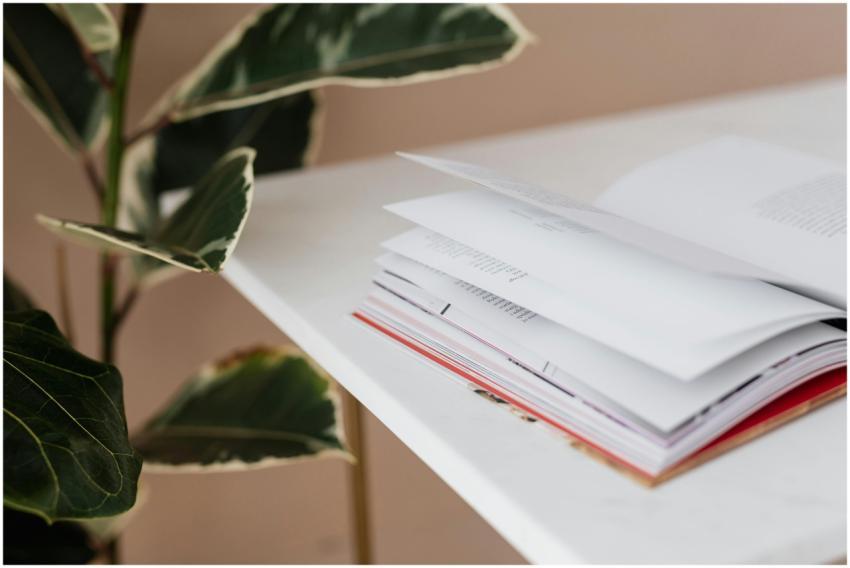 Book that has been left open on white table near b