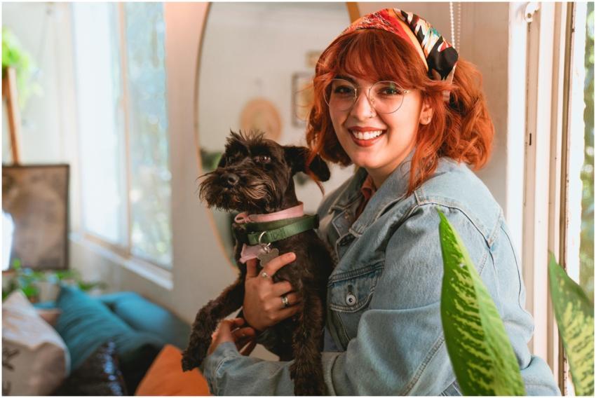 Happy woman with red hair holding a Schnauzer dog