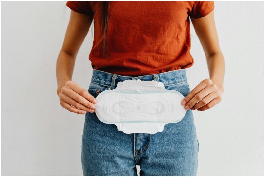A woman showing a sanitary pad, highlighting menst