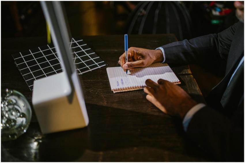 A businessman in a suit writing notes on a noteboo