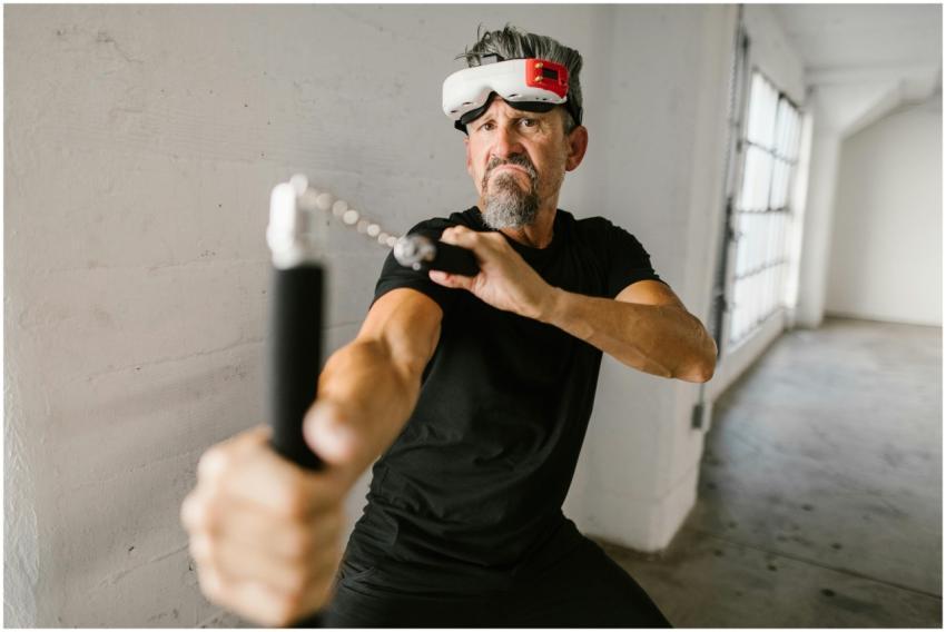 Elderly man practicing with nunchucks while wearin