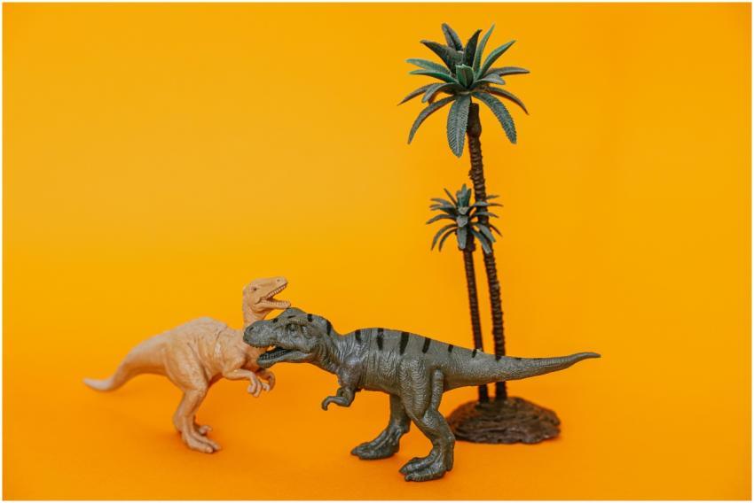 Close-up of dinosaur figurines and palm trees on a