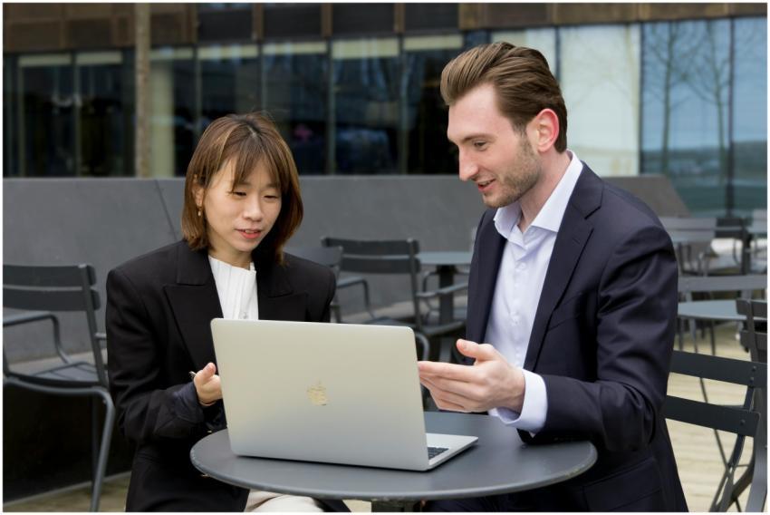 Two professionals collaborating over a laptop duri