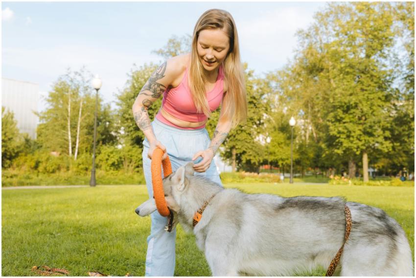A tattooed woman enjoying playtime with her Siberi