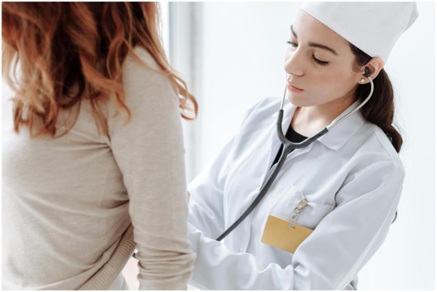 A female doctor in a white coat using a stethoscop