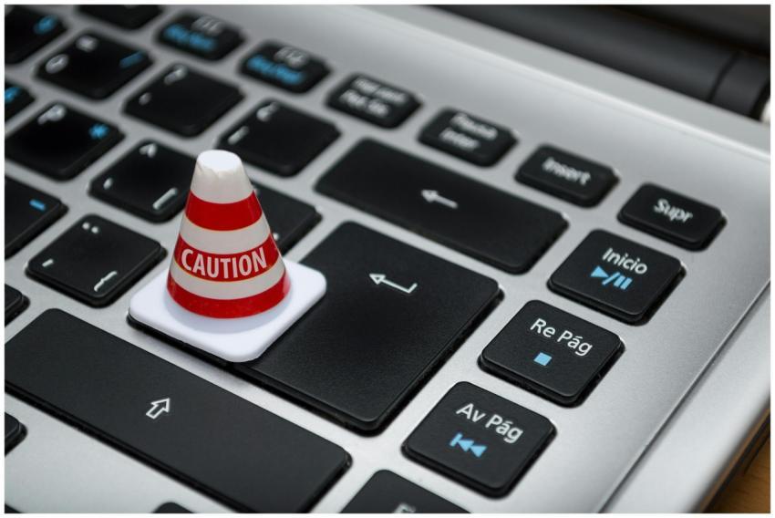 Miniature caution cone on a computer keyboard symb