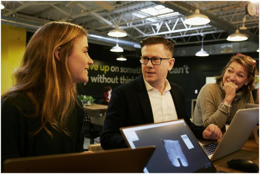 Three colleagues engaged in a lively discussion in