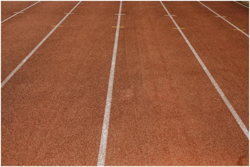 Empty red running track with marked lanes, ready f
