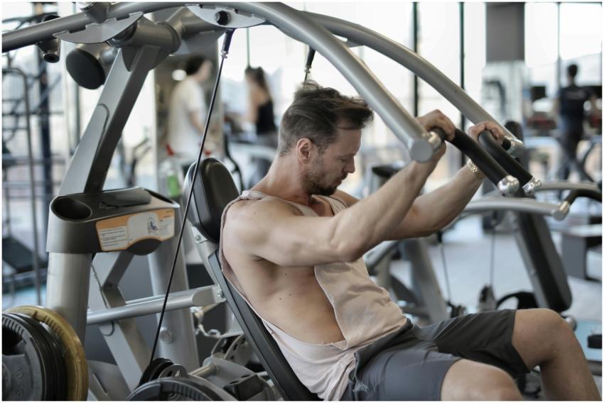 Adult male using gym equipment for strength traini