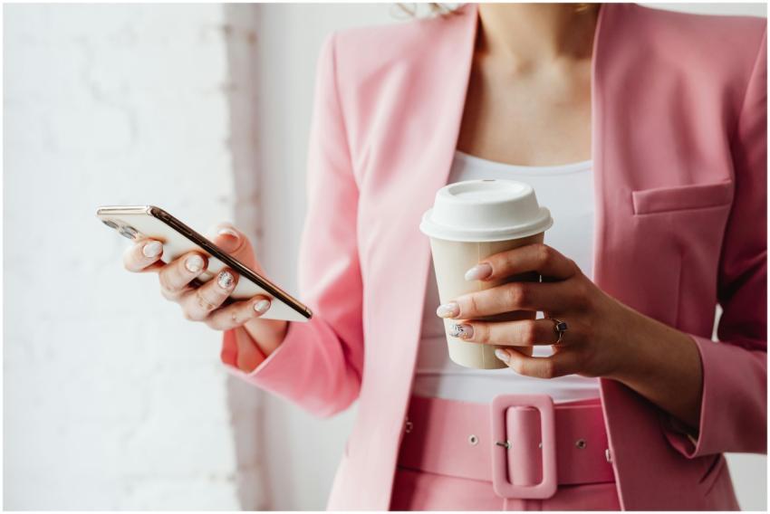 Fashionable woman with coffee cup and phone in a p
